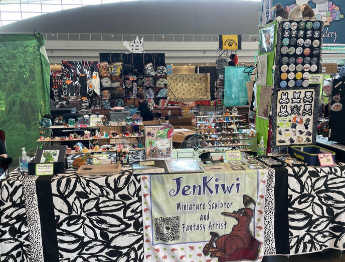 Anthrocon 2026 Setup (Overhead banner & green tablecloth lost in transit to con; have since been replaced)